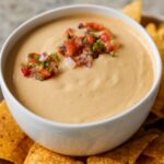 cashew nacho cheese in a serving bowl topped with salsa