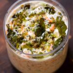 savory overnight oats topped with Indian spiced tempering in a glass jar