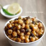 sukha chana served in a white bowl with a side bowl of onion slice and green chili.