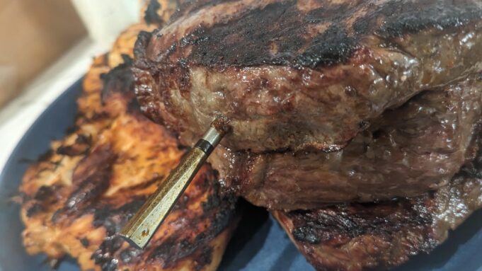 A close look at the Meater probe inside a steak