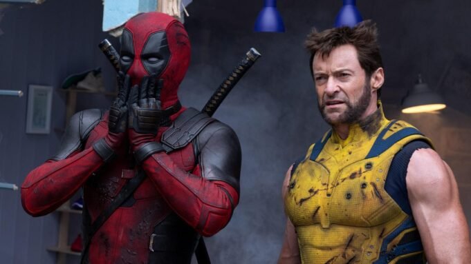 deadpool covers his mouth in shock while standing next to Wolverine